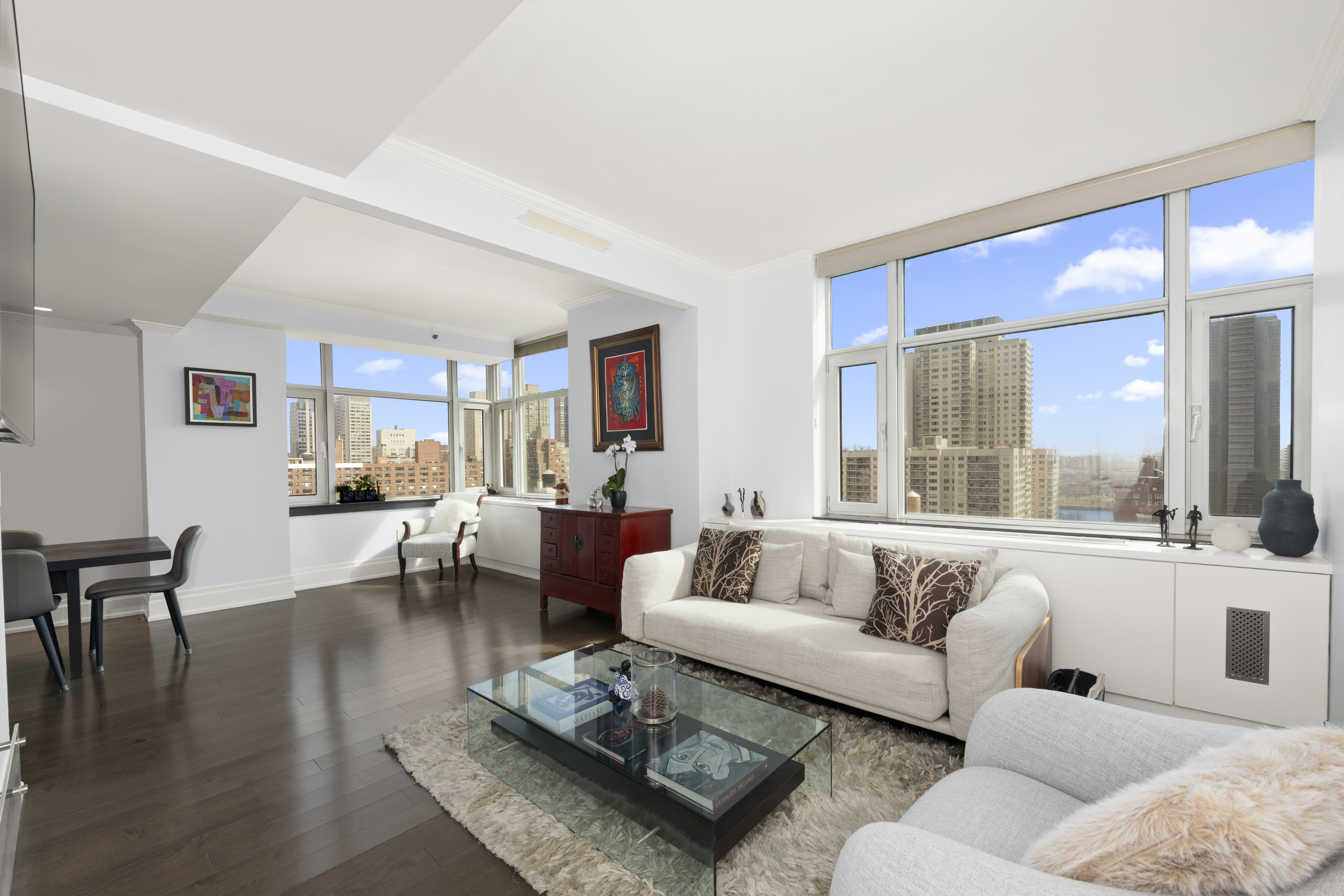 404 East 76th Street, Unit 17A Manhattan, NY 10021 - Photo 1 of 18 a living room with furniture wooden floor and a large window