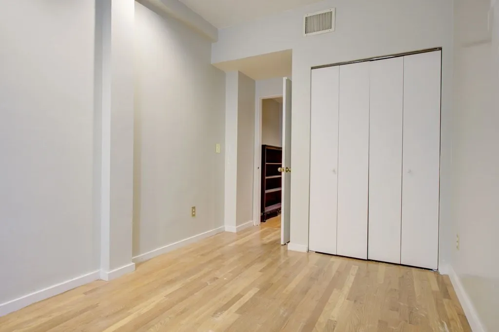 a view of an empty room with wooden floor