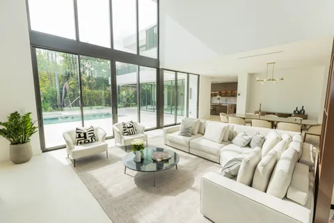 a living room with furniture and floor to ceiling windows
