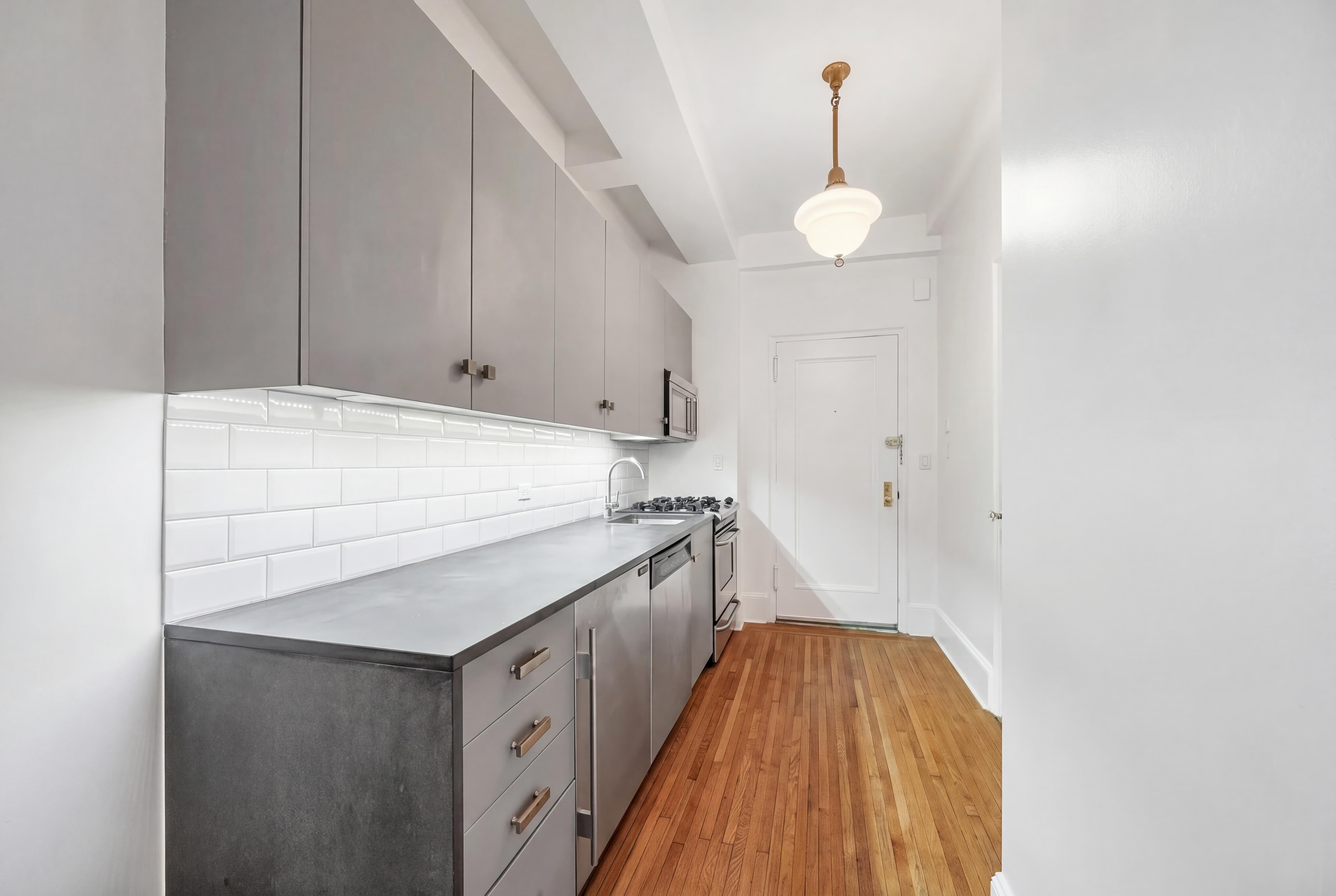 77 Park Avenue, Unit 6H Manhattan, NY 10016 - Photo 5 of 9 a kitchen with a cabinets and chandelier