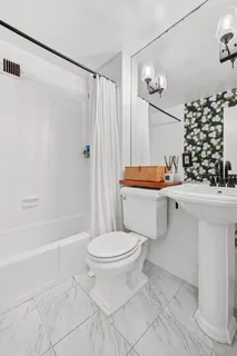 a bathroom with a sink toilet and shower