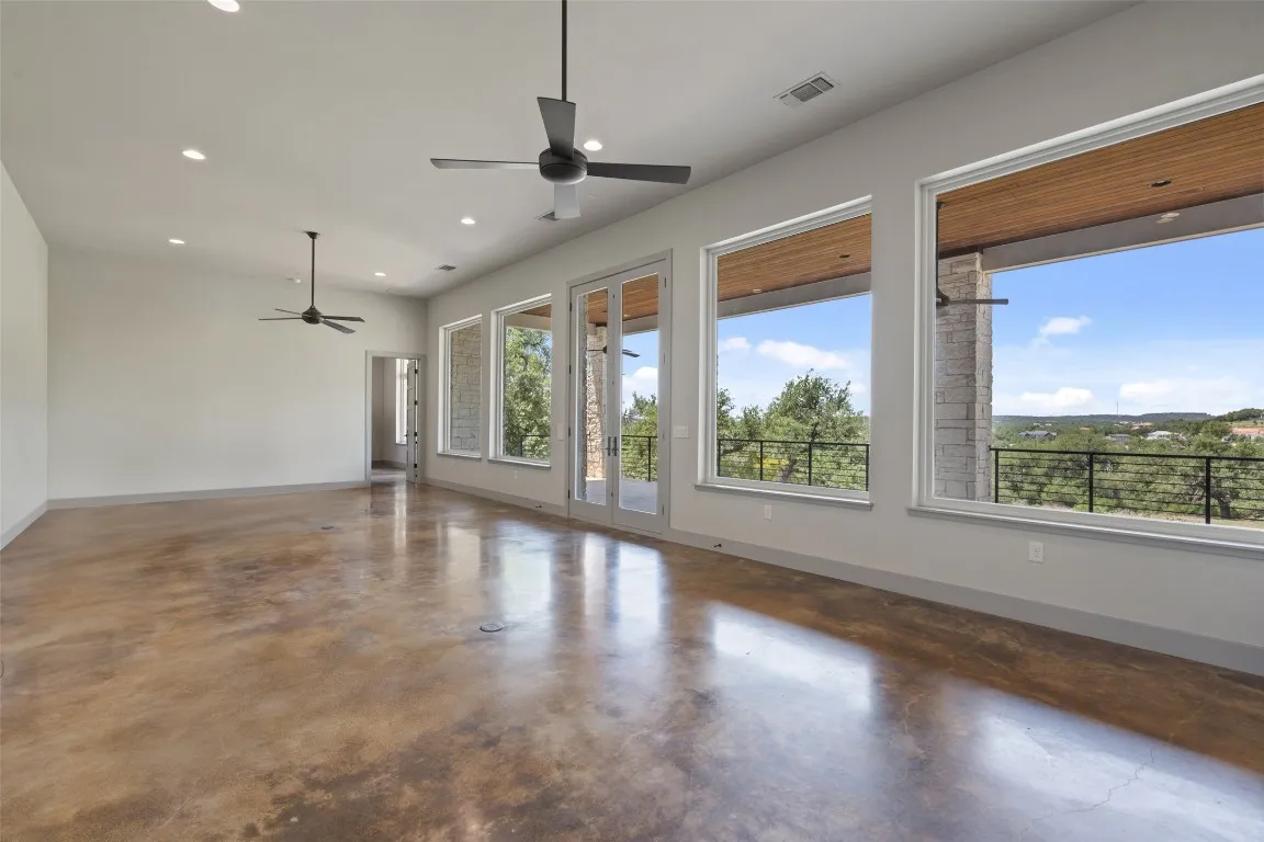 a view of an empty room with a window and wooden floor
