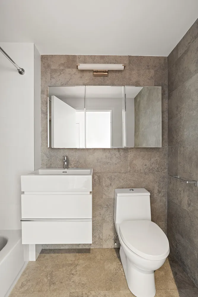 a bathroom with a toilet a sink and mirror