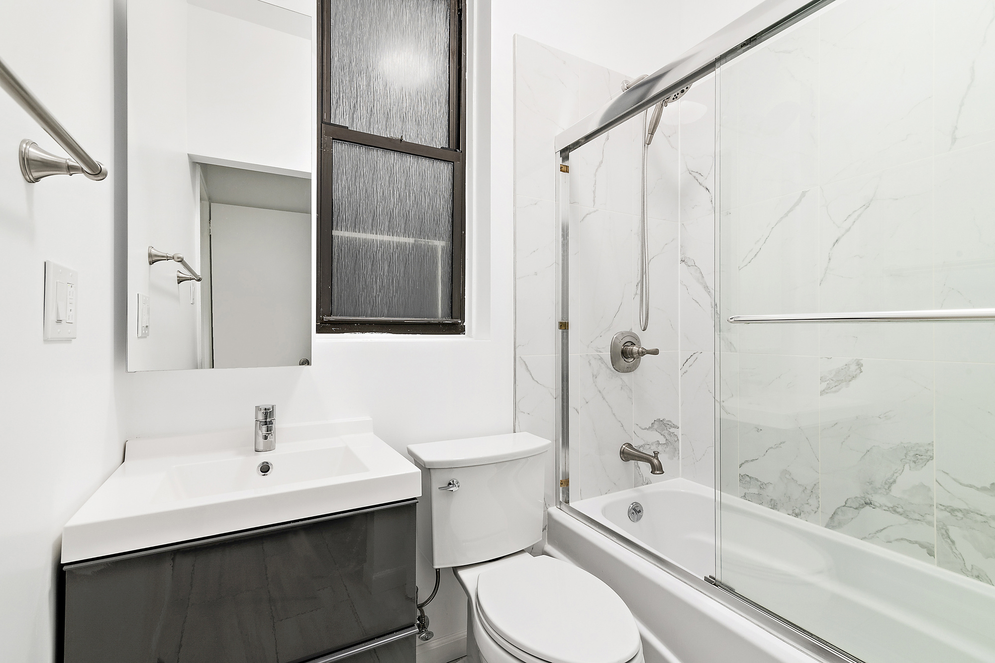 350 West 56th Street, Unit 1A Manhattan, NY 10019 - Photo 4 of 17 a bathroom with a sink a toilet and shower