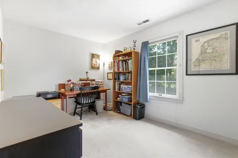 a view of a workspace with furniture and a window