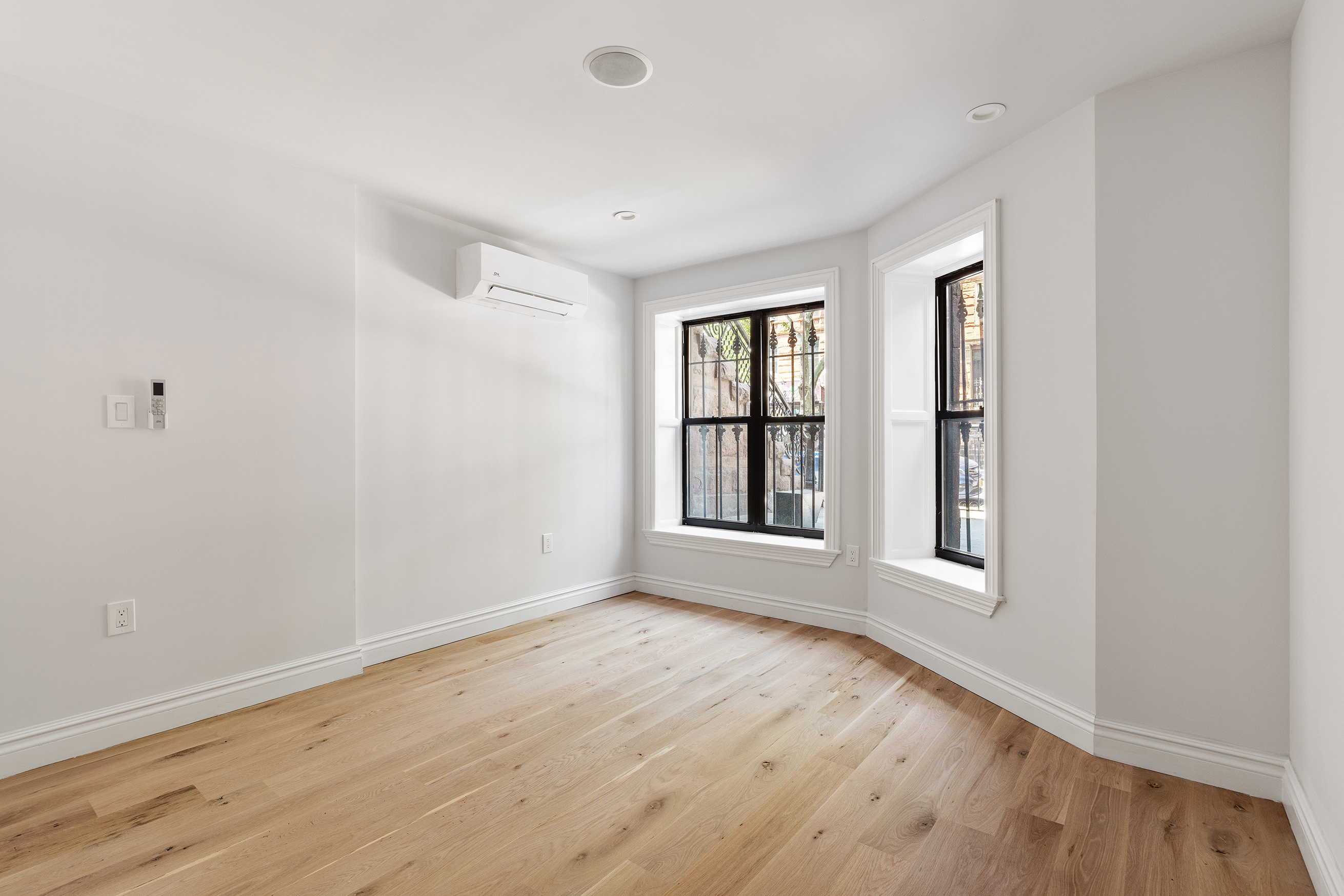698 Macon Street Brooklyn, NY 11233 - Photo 10 of 17 an empty room with wooden floor and windows