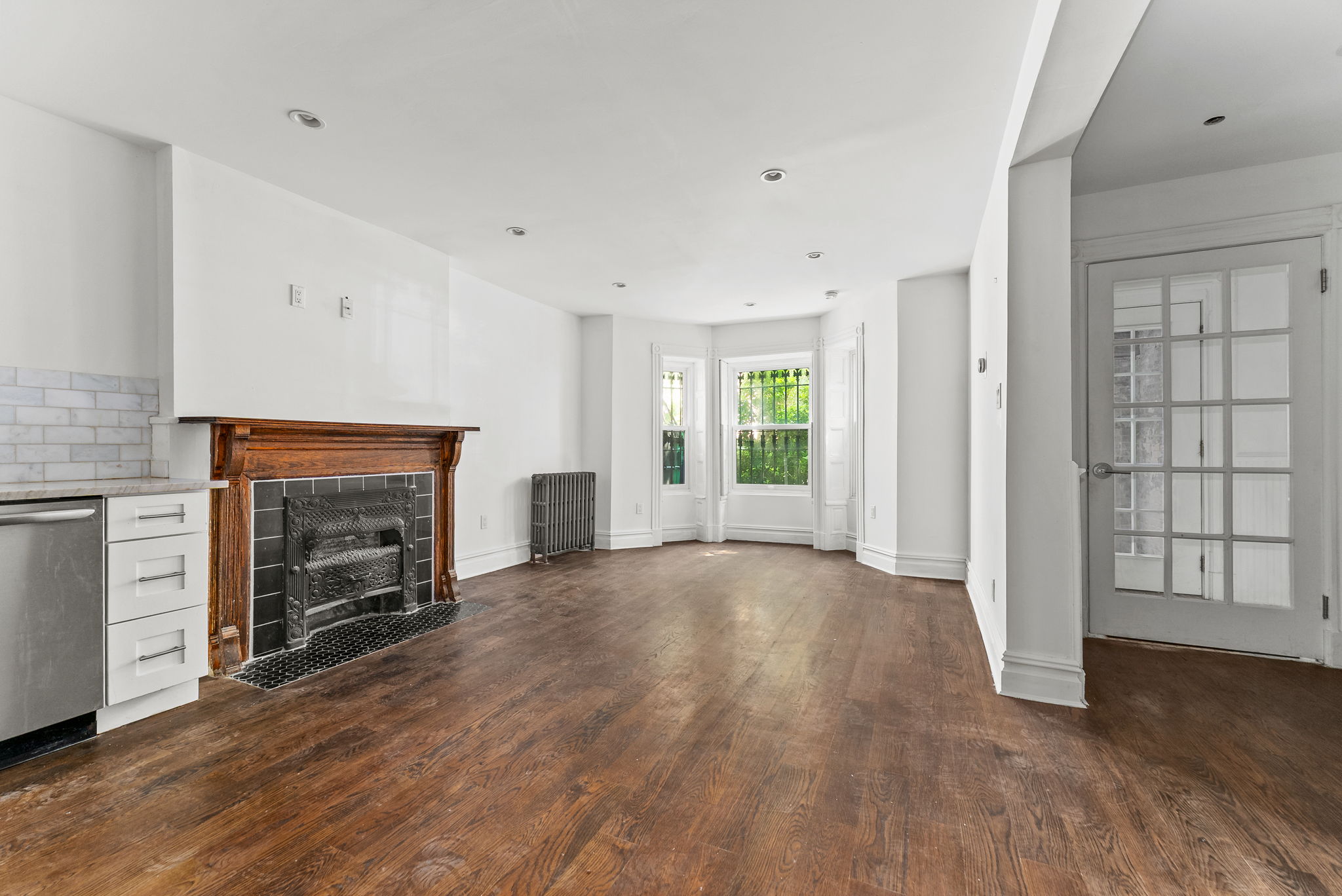 an empty room with windows and a fireplace