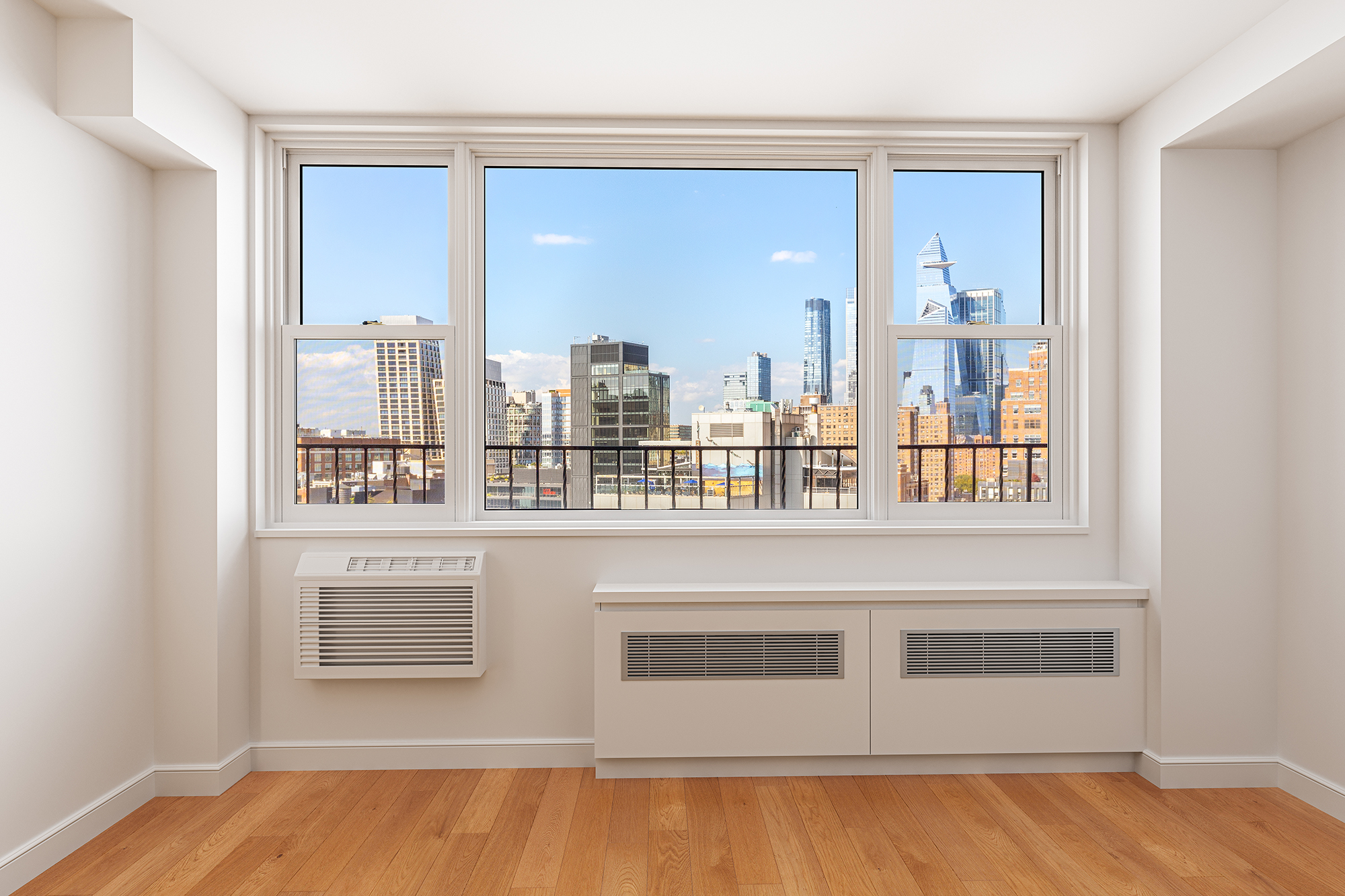 61 Jane Street, Unit 19J Manhattan, NY 10014 - Photo 4 of 16 a view of a kitchen with stainless steel appliances wooden floor and a window