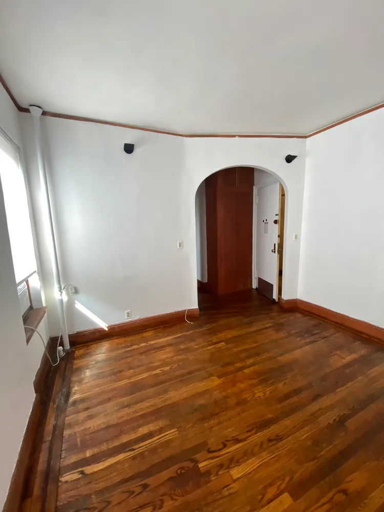 a view of empty room with wooden floor