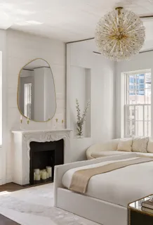 a bedroom with a bed a fireplace and a chandelier