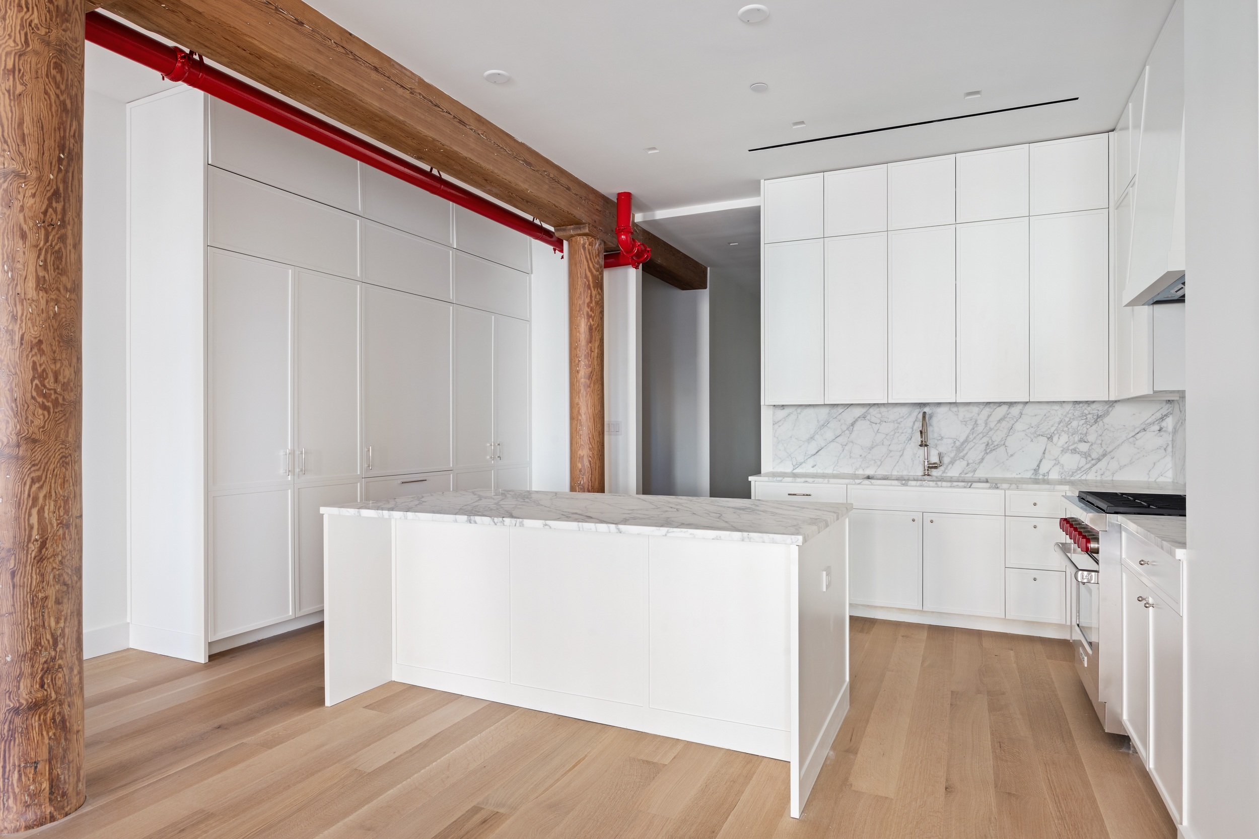 243 West Broadway, Unit 3 Manhattan, NY 10013 - Photo 9 of 25 a kitchen with a sink a stove cabinets and wooden floor