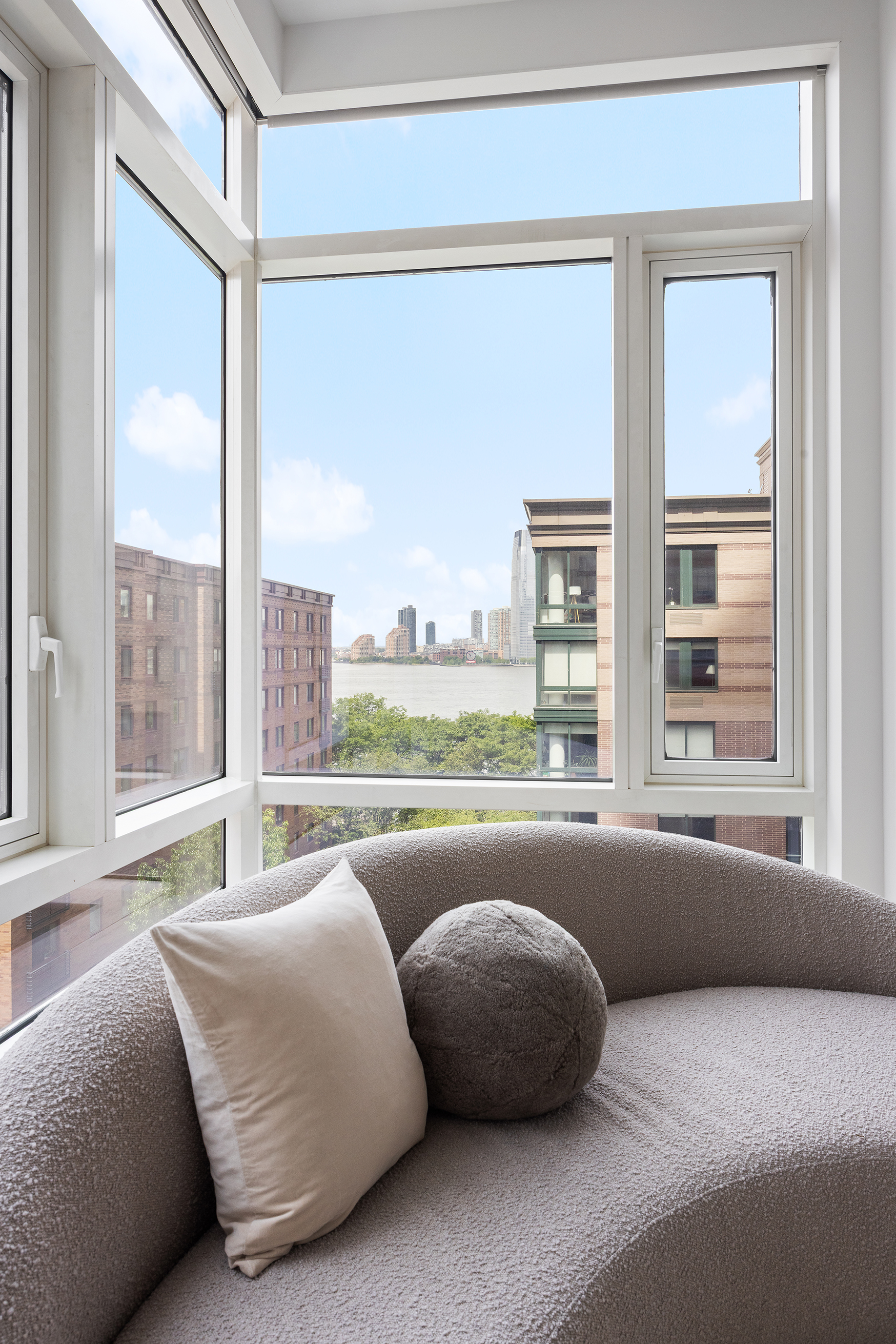 70 Little West Street, Unit 7L Manhattan, NY 10004 - Photo 8 of 25 a living room with couch and a large window