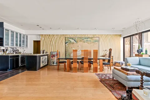a living room with furniture a large window and a dining table