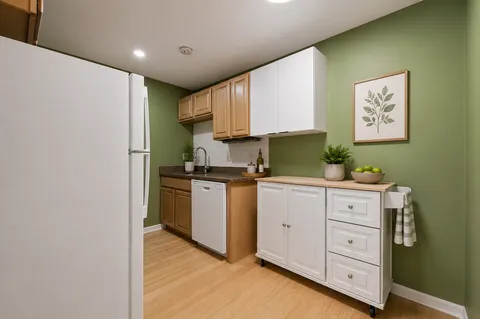 a kitchen with cabinets appliances and a wooden floor