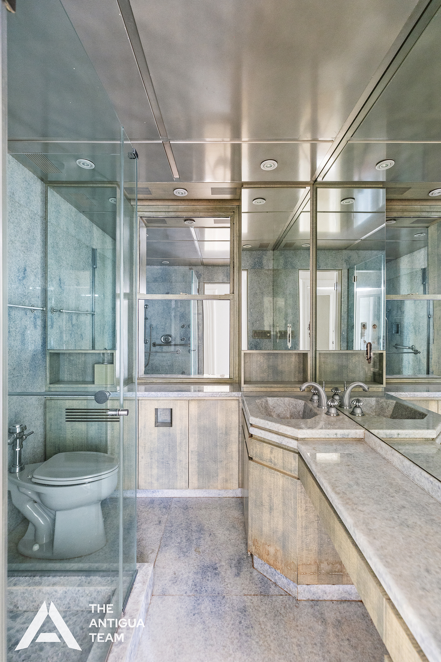 45 East 66th Street, Unit 4W Manhattan, NY 10065 - Photo 22 of 27 a large bathroom with a granite countertop toilet a sink and a bathtub