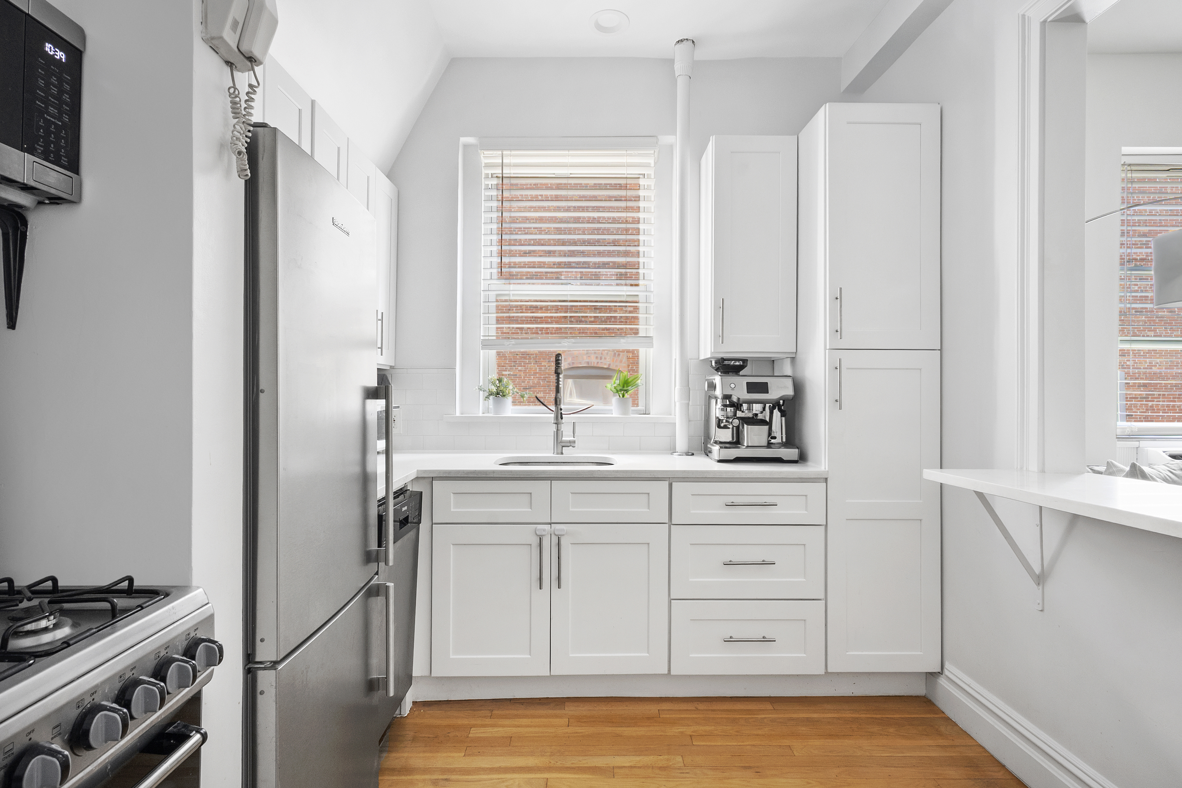 345 West 70th Street, Unit 5E Manhattan, NY 10023 - Photo 1 of 10 a kitchen with cabinets appliances and a window