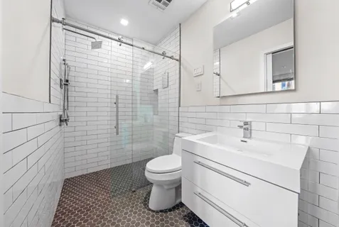 a bathroom with a sink a toilet and shower