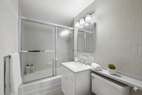 a bathroom with a sink and mirror with toilet