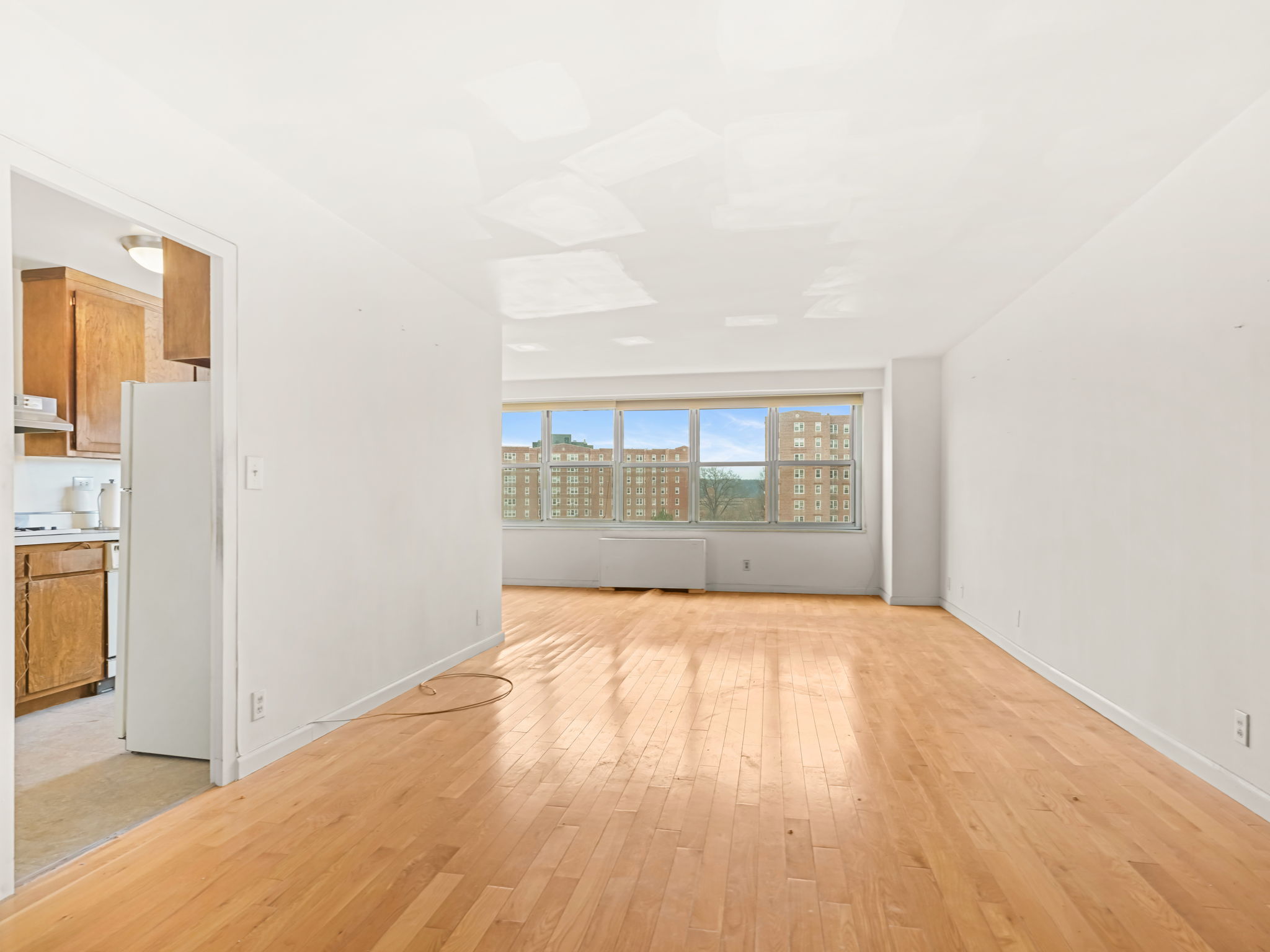 555 Kappock Street, Unit 11J Bronx, NY 10463 - Photo 3 of 24 a view of an empty room with wooden floor and a window
