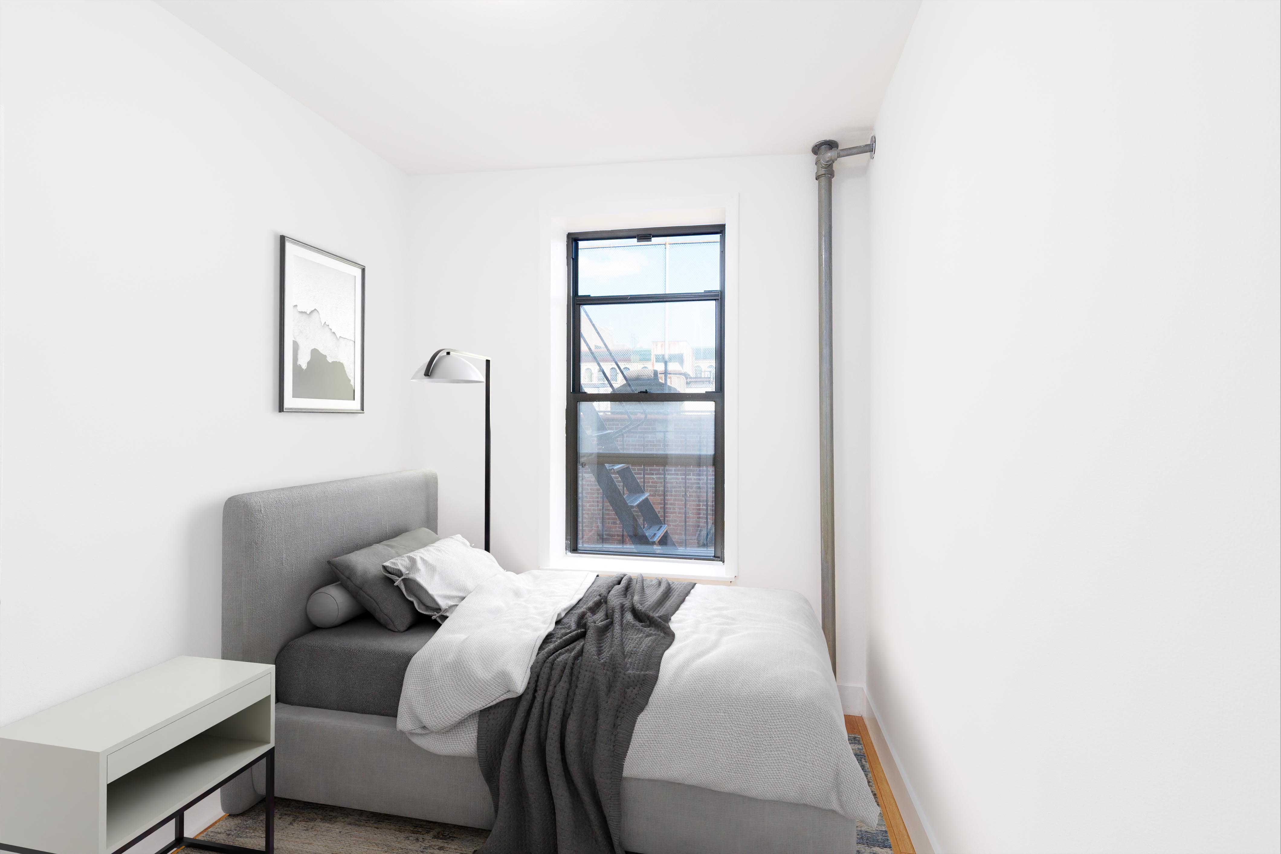 517 West 144th Street, Unit 9 Manhattan, NY 10031 - Photo 7 of 22 a bedroom with a bed and a window