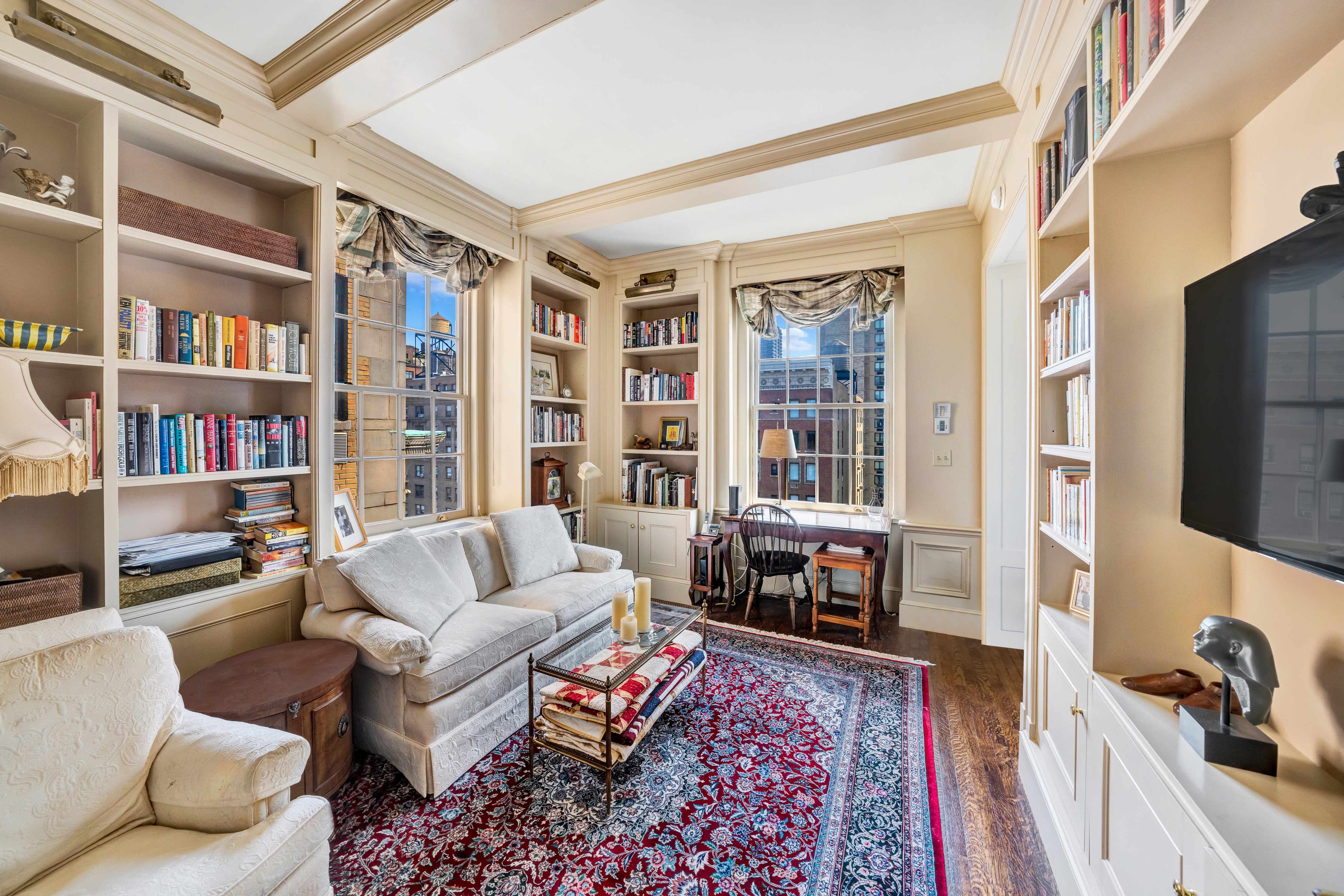 1060 Park Avenue, Unit 13G Manhattan, NY 10128 - Photo 8 of 11 a living room with furniture and a book shelf
