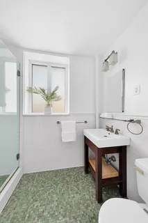 a bathroom with a sink a toilet and window