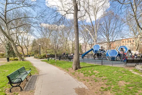 a view of a park with iron fence