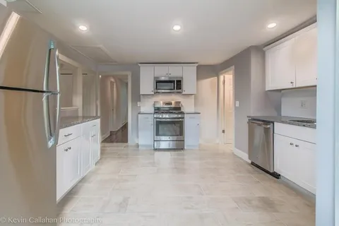 a large kitchen with white cabinets