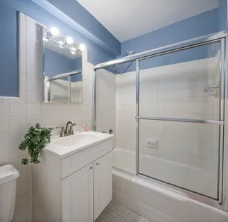 a bathroom with a shower sink vanity and mirror