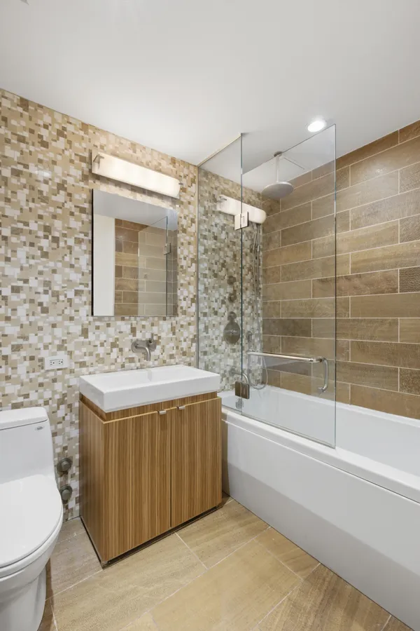 a bathroom with a granite countertop sink a toilet and bathtub