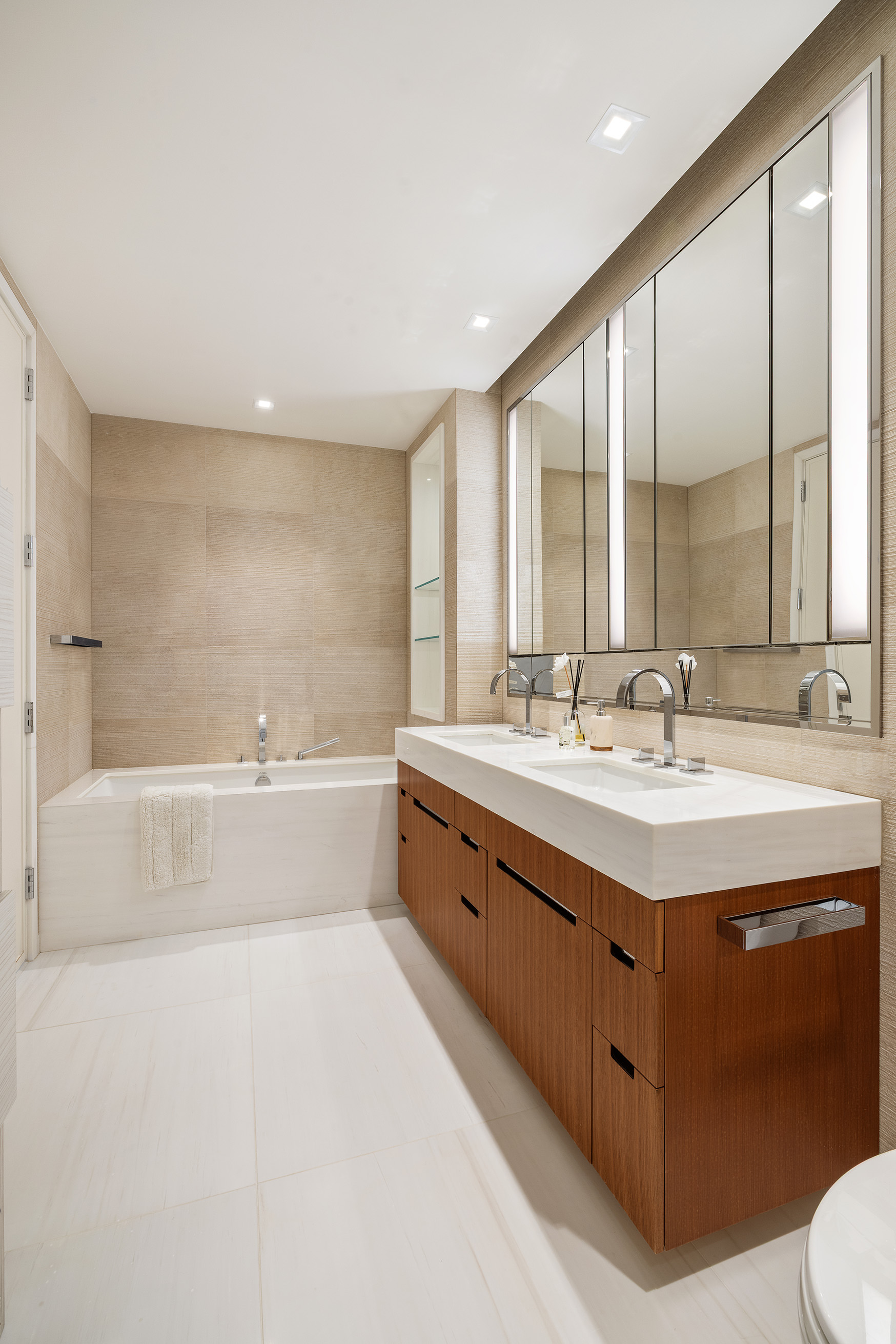 1 West End Avenue, Unit 25F Manhattan, NY 10023 - Photo 7 of 15 a spacious bathroom with a double vanity sink large mirror and a bathtub
