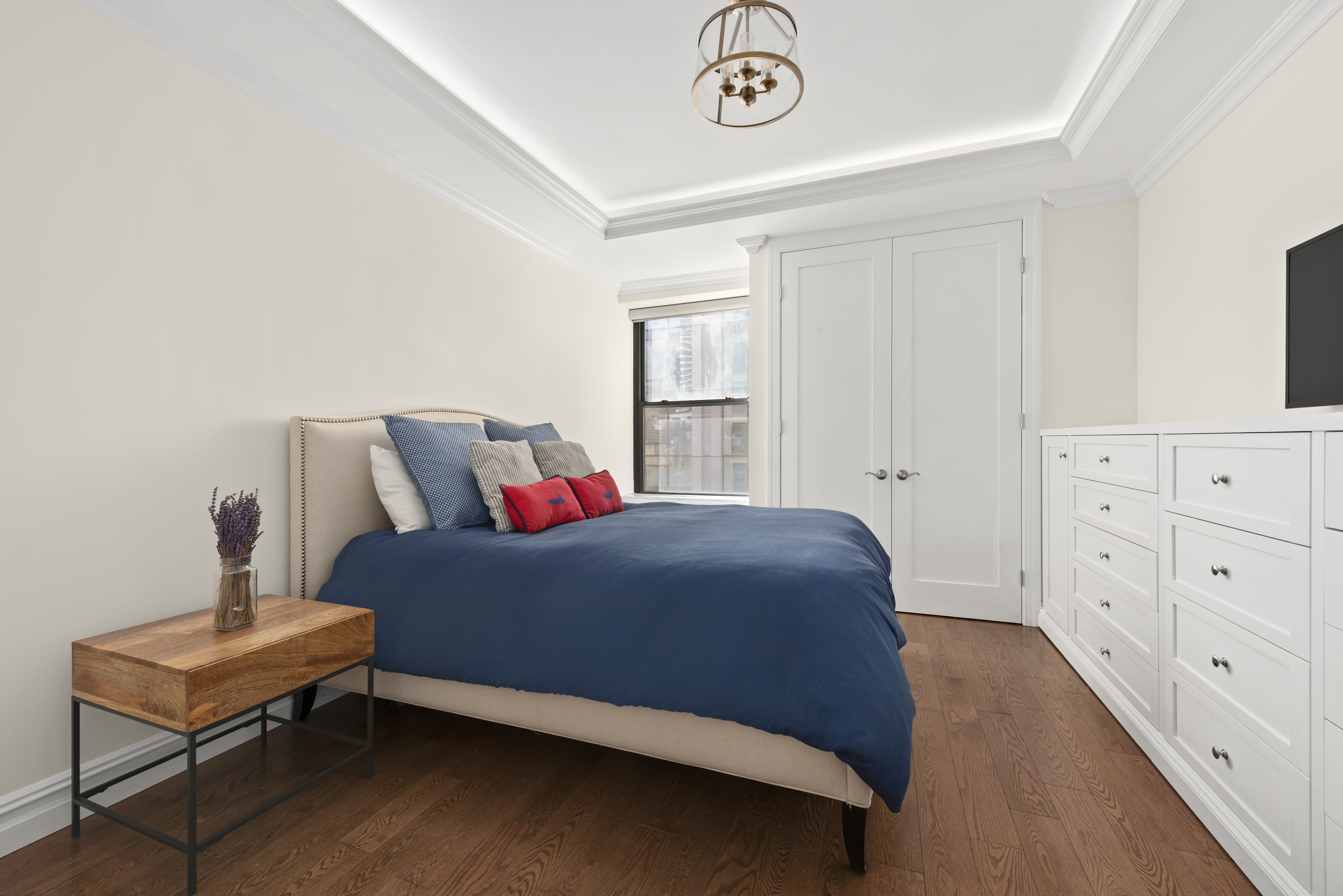 153 East 87th Street, Unit 6D Manhattan, NY 10128 - Photo 4 of 8 a bedroom with a bed and cabinet