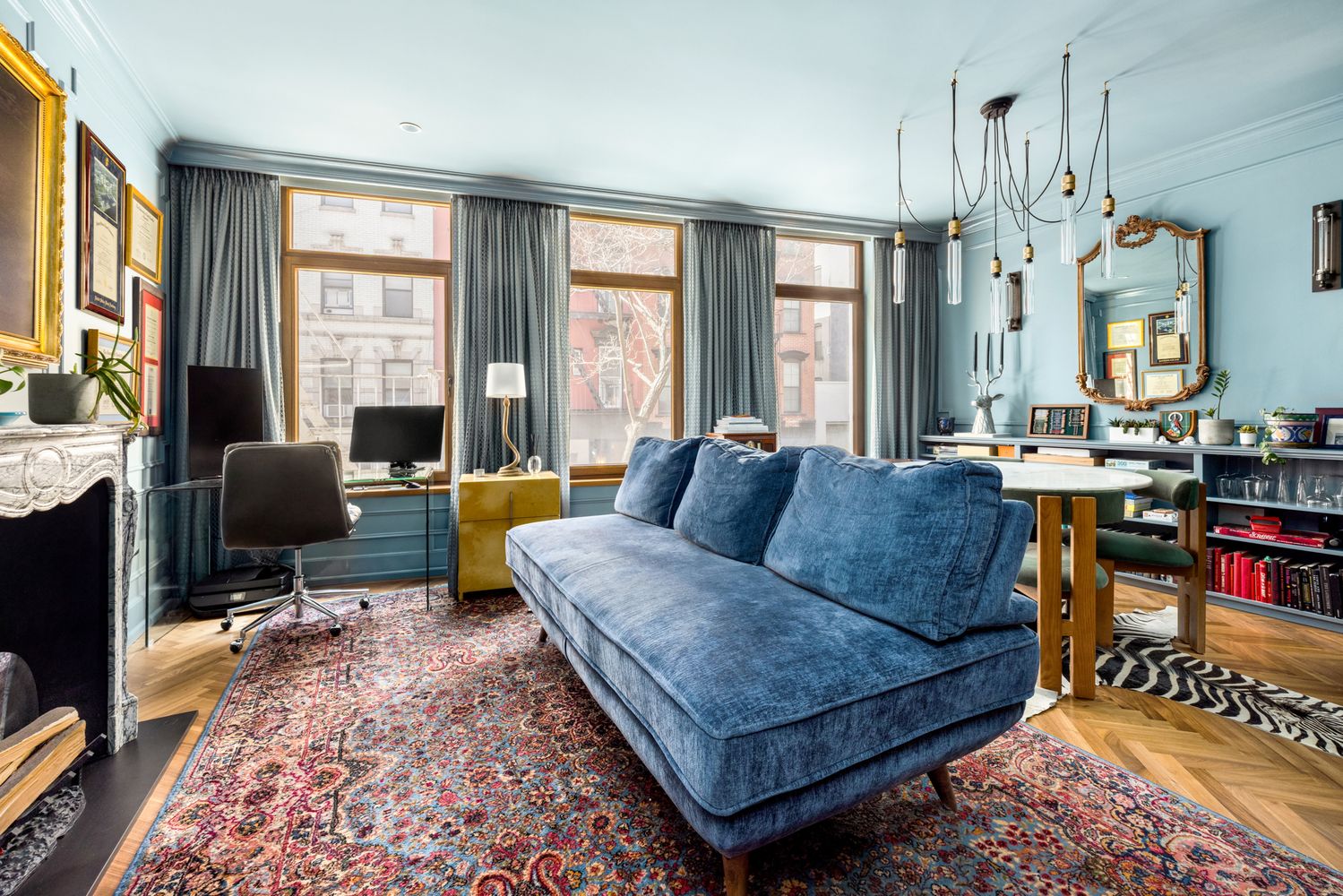 a living room with furniture a fireplace and large windows