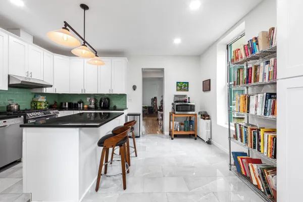 a kitchen with stainless steel appliances kitchen island granite countertop a refrigerator and a stove