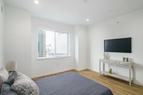 a bedroom with a bed and a flat screen tv