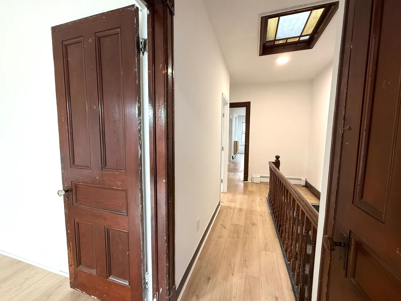 a view of a hallway with wooden floor and staircase