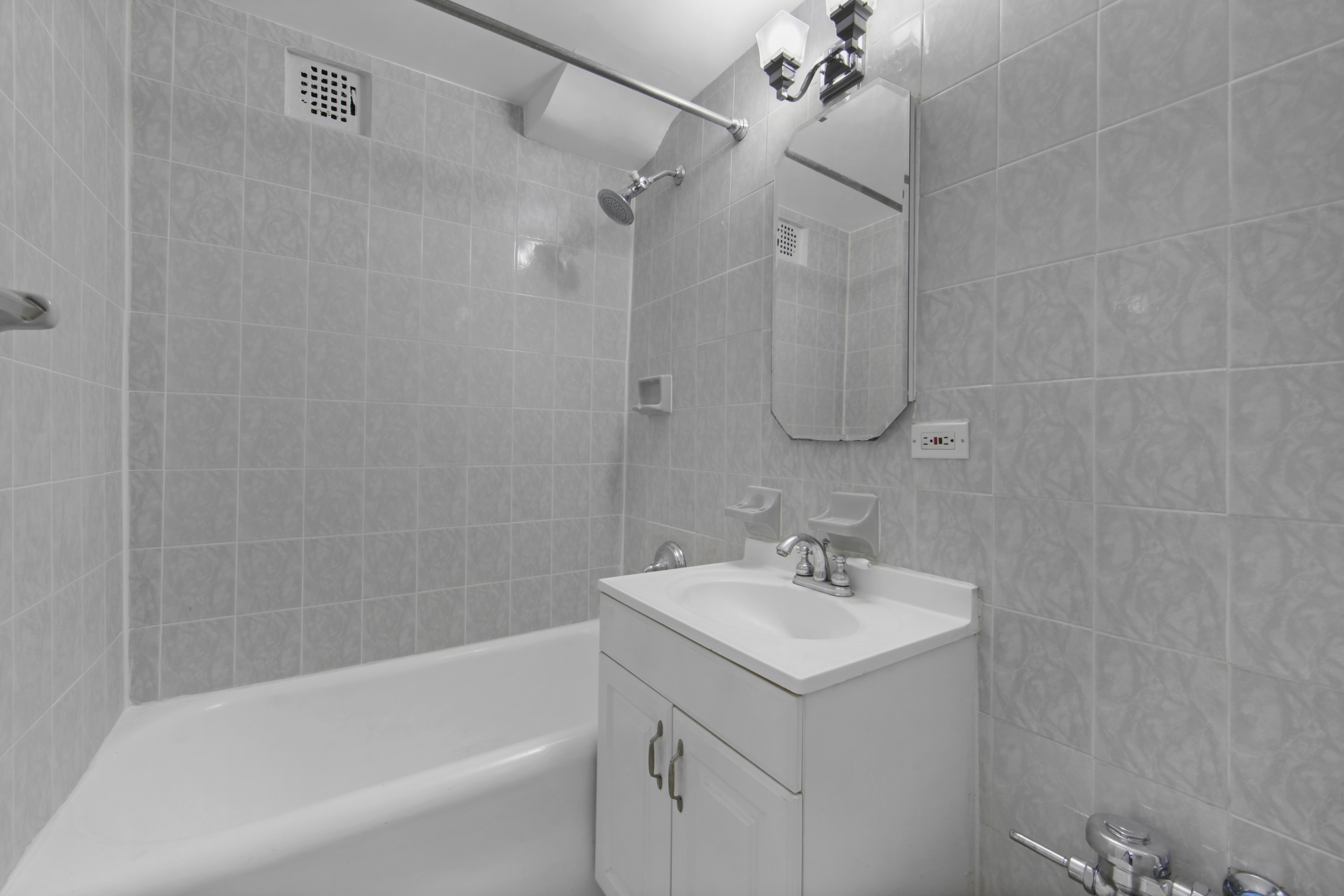 45 Tudor City Place, Unit 1902 Manhattan, NY 10017 - Photo 9 of 14 a bathroom with a sink a toilet and shower