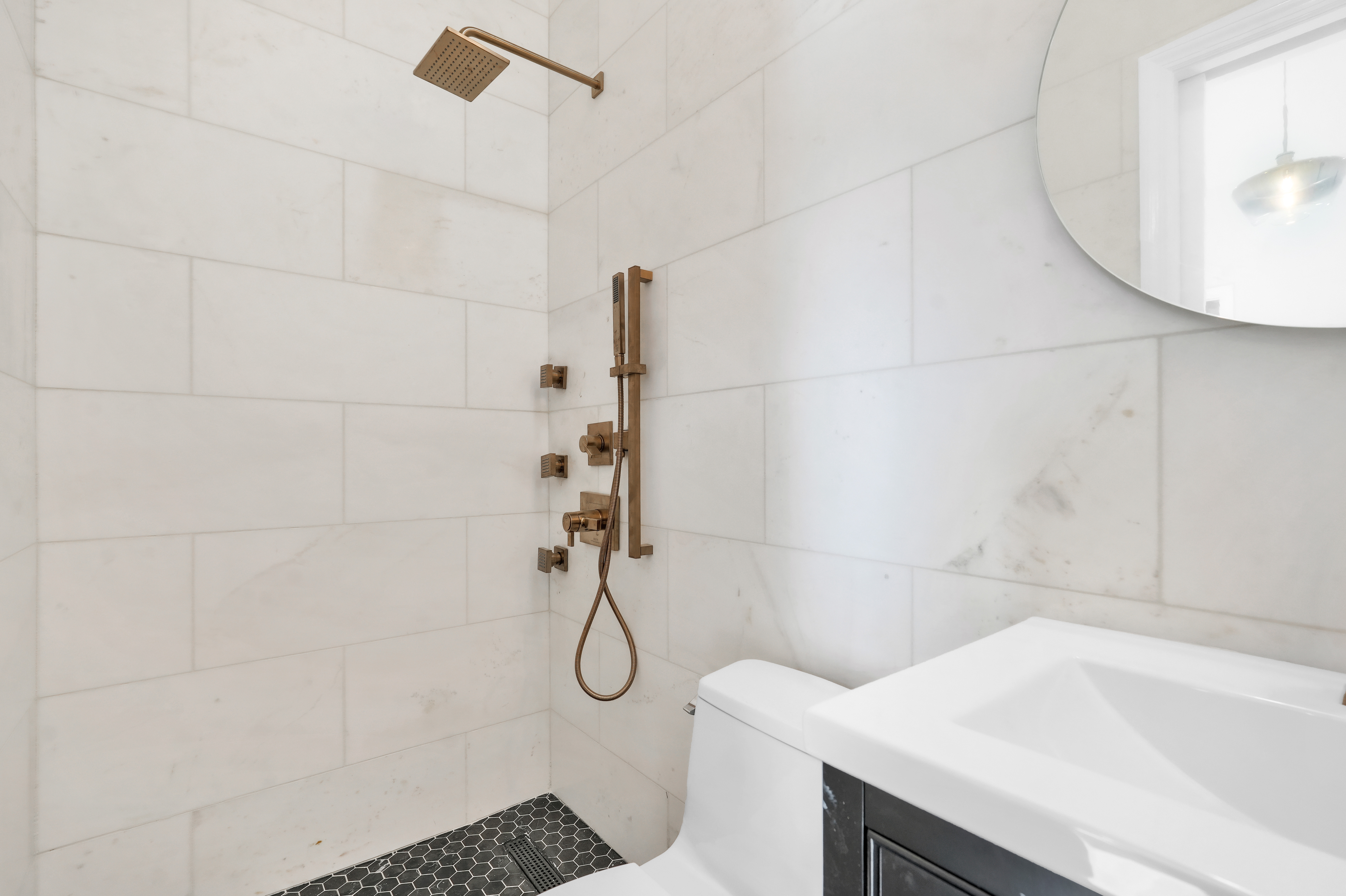 473 Monroe Street Brooklyn, NY 11221 - Photo 27 of 40 a bathroom with a sink a toilet and shower