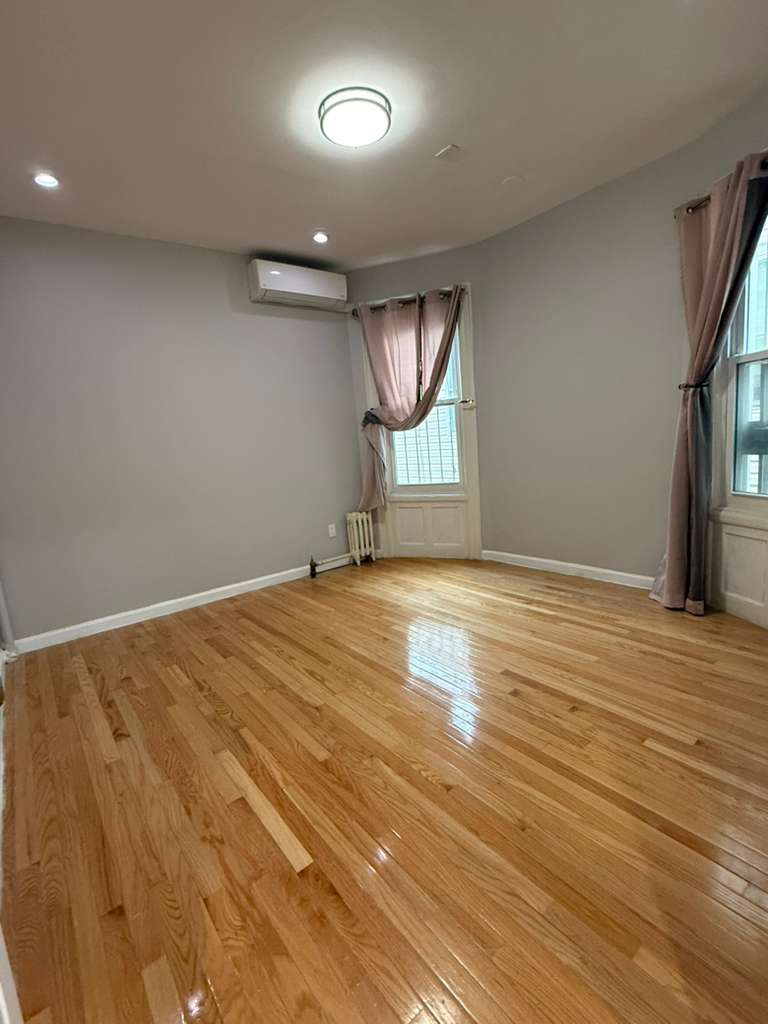 641 East 4th Street, Unit 1 Brooklyn, NY 11218 - Photo 8 of 15 an empty room with wooden floor and windows