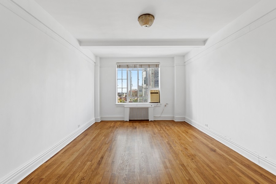 101 Lafayette Avenue, Unit 12L Brooklyn, NY 11217 - Photo 2 of 7 an empty room with wooden floor and windows