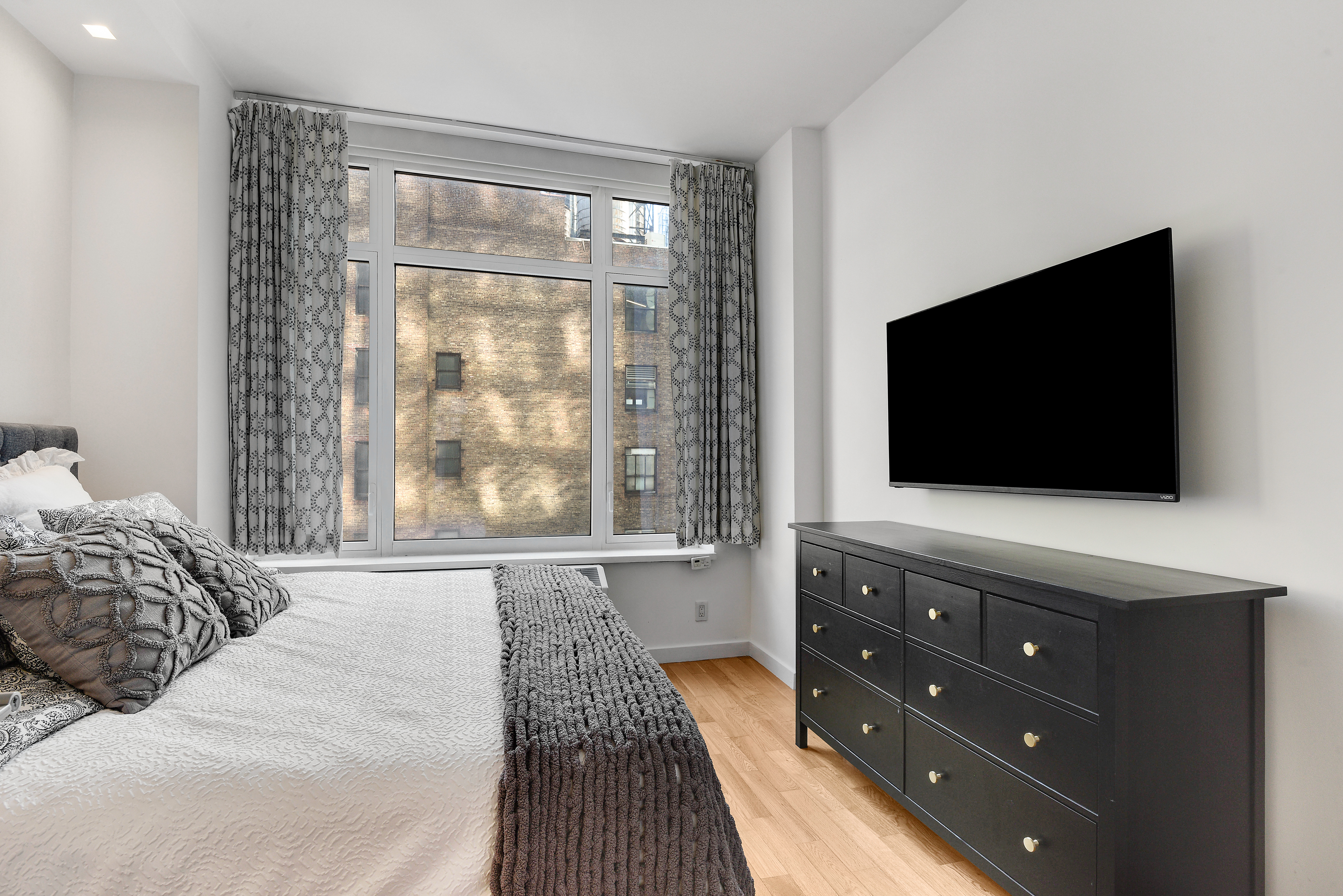 325 5th Avenue, Unit 16C Manhattan, NY 10016 - Photo 10 of 25 a bedroom with a bed and a flat screen tv