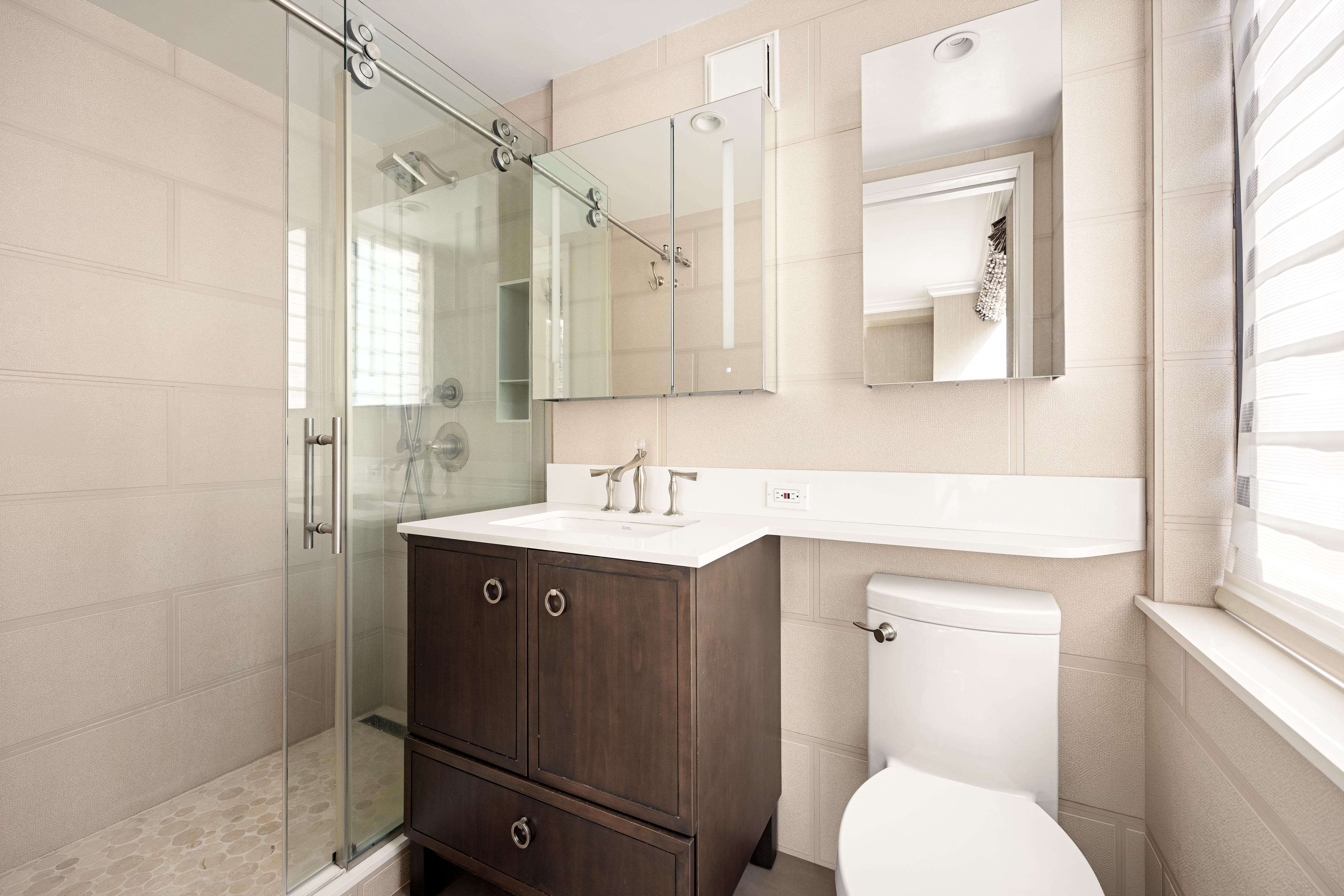 171 East 84th Street, Unit 7B Manhattan, NY 10028 - Photo 12 of 19 a bathroom with a sink toilet and shower