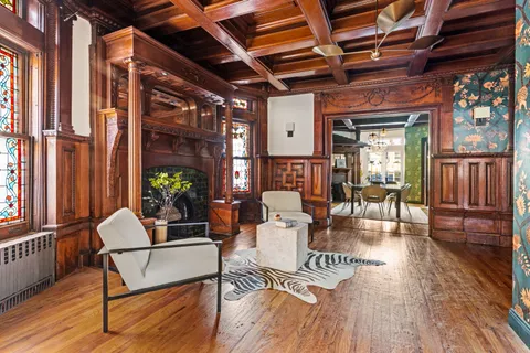 a living room with furniture a wooden floor and next to a window