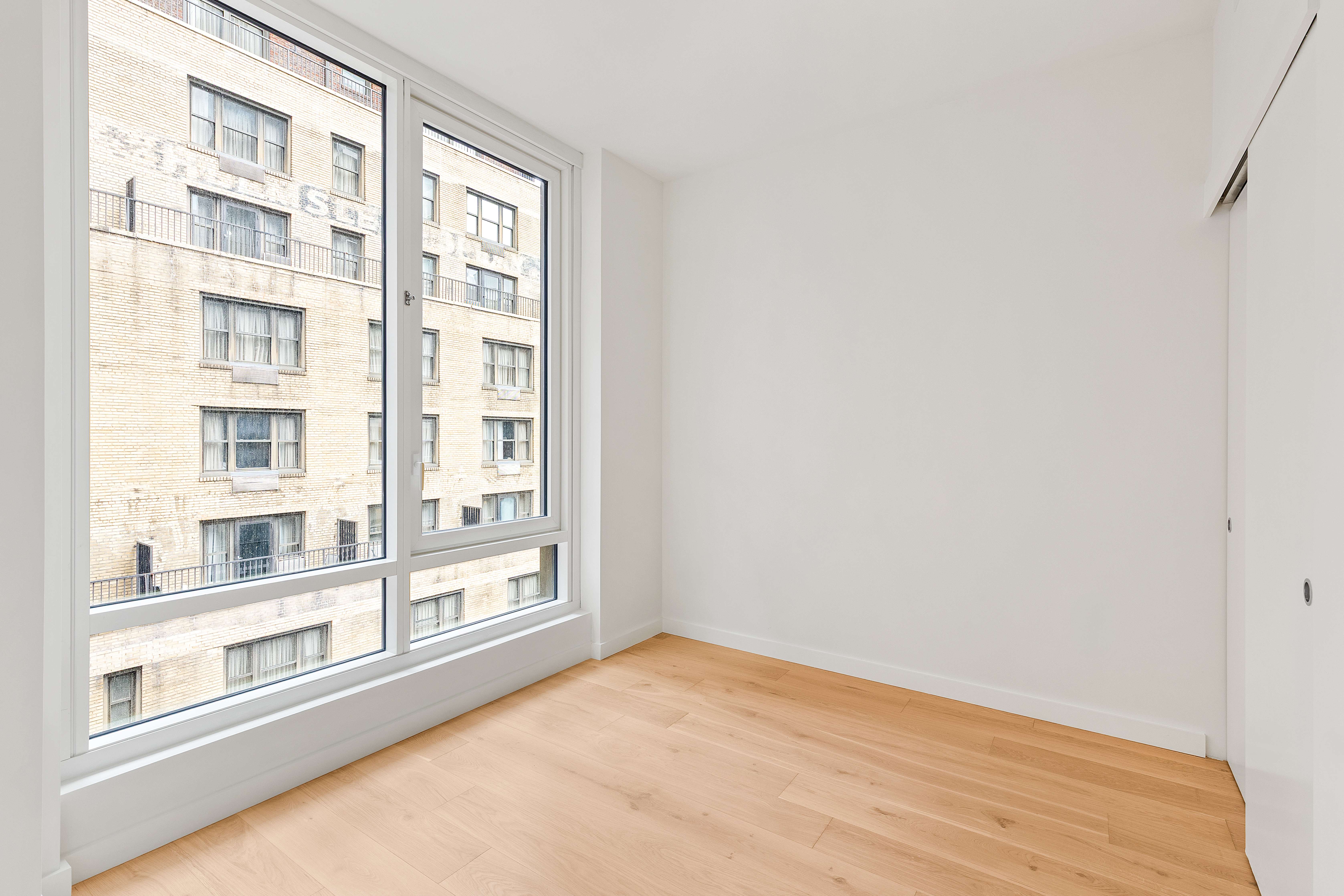 135 East 47th Street, Unit 12C Manhattan, NY 10017 - Photo 5 of 15 a view of an empty room with a window