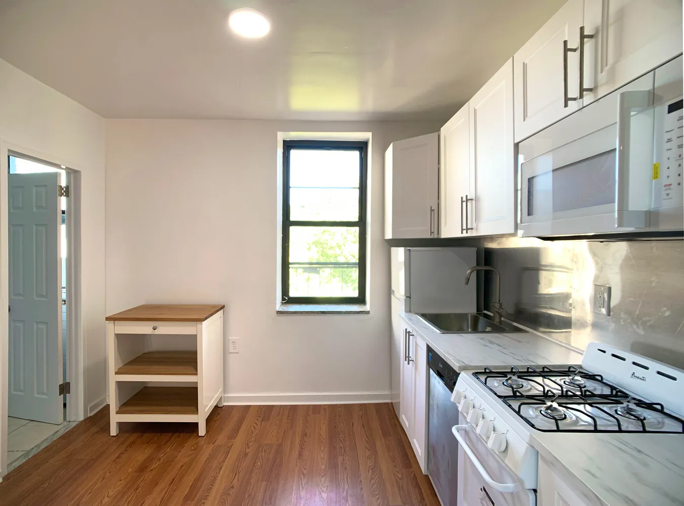 a view of a room with wooden floor and a window