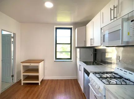 a view of a room with wooden floor and a window