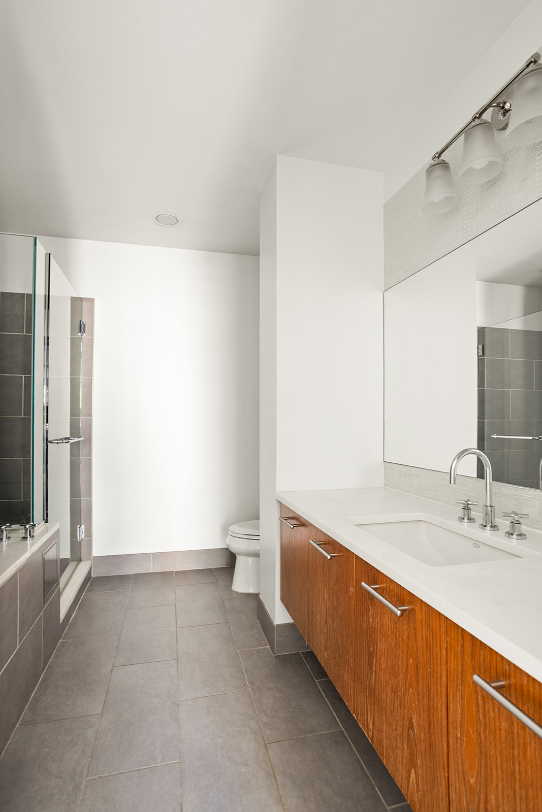 130 West 19th Street, Unit 7C Manhattan, NY 10011 - Photo 6 of 13 a bathroom with a tub sink and mirror