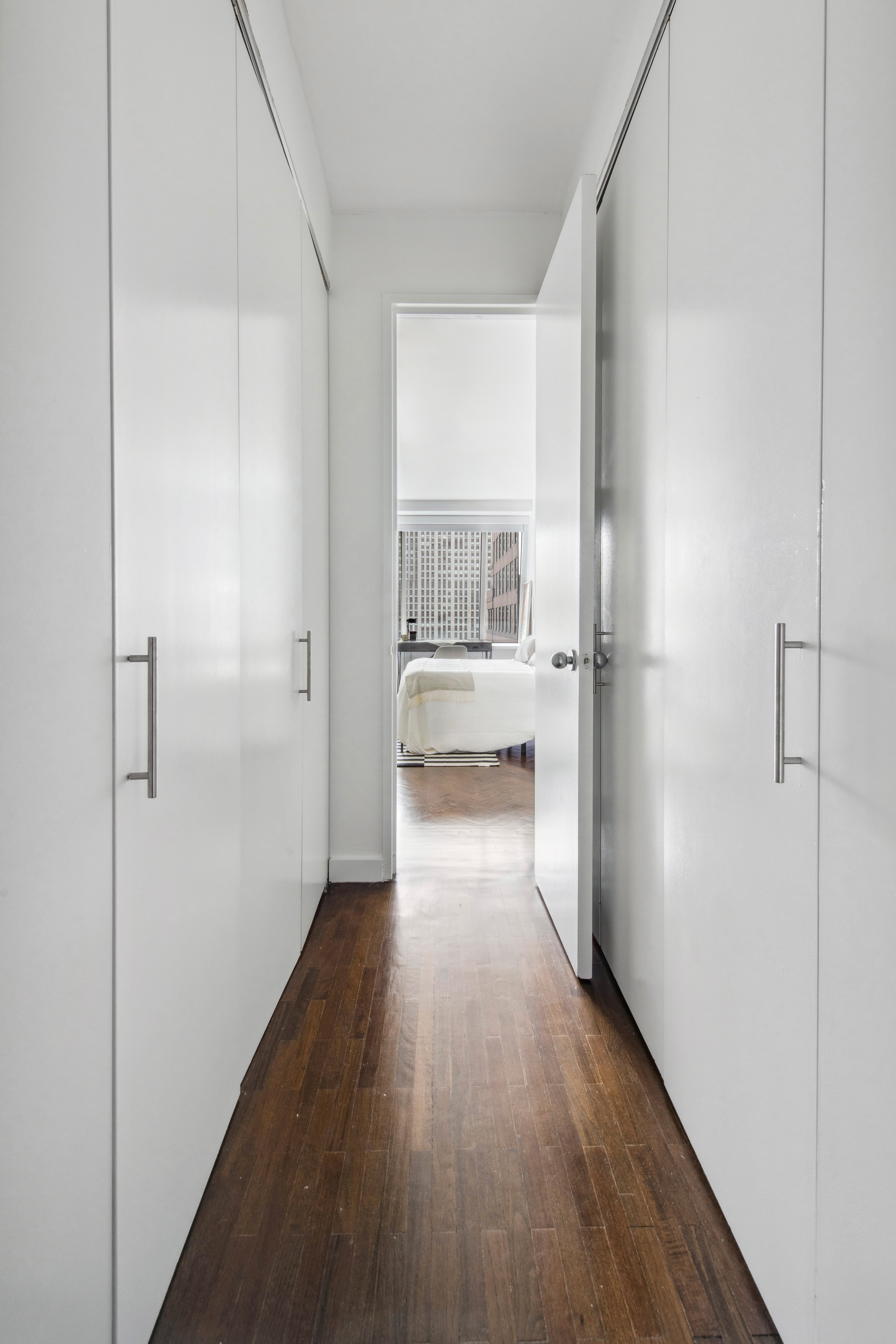 15 West 53rd Street, Unit 31C Manhattan, NY 10019 - Photo 5 of 14 a view of a hallway with wooden floor and a living room