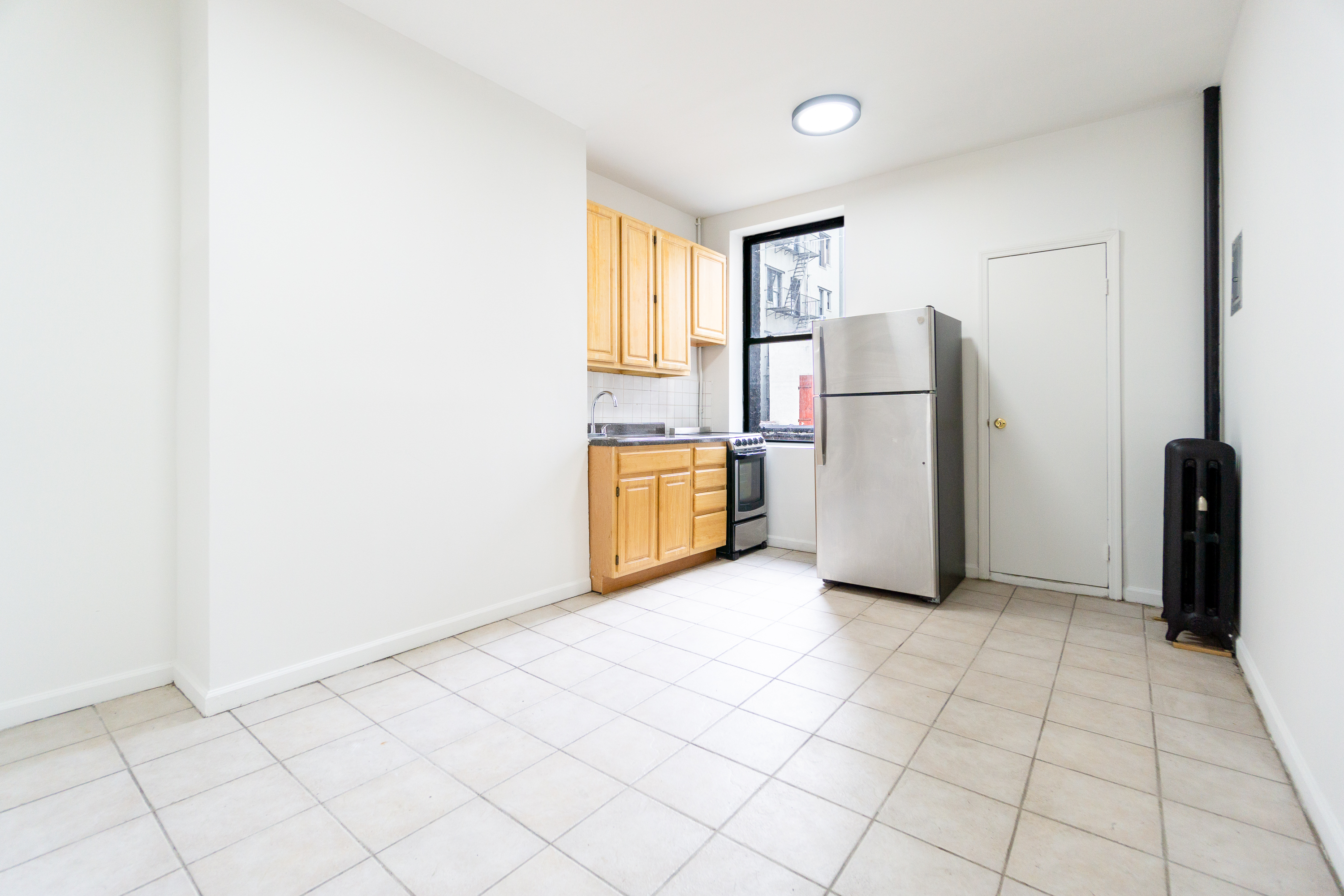 215 East 5th Street, Unit 3 Manhattan, NY 10003 - Photo 16 of 25 a view of a refrigerator in kitchen and a window