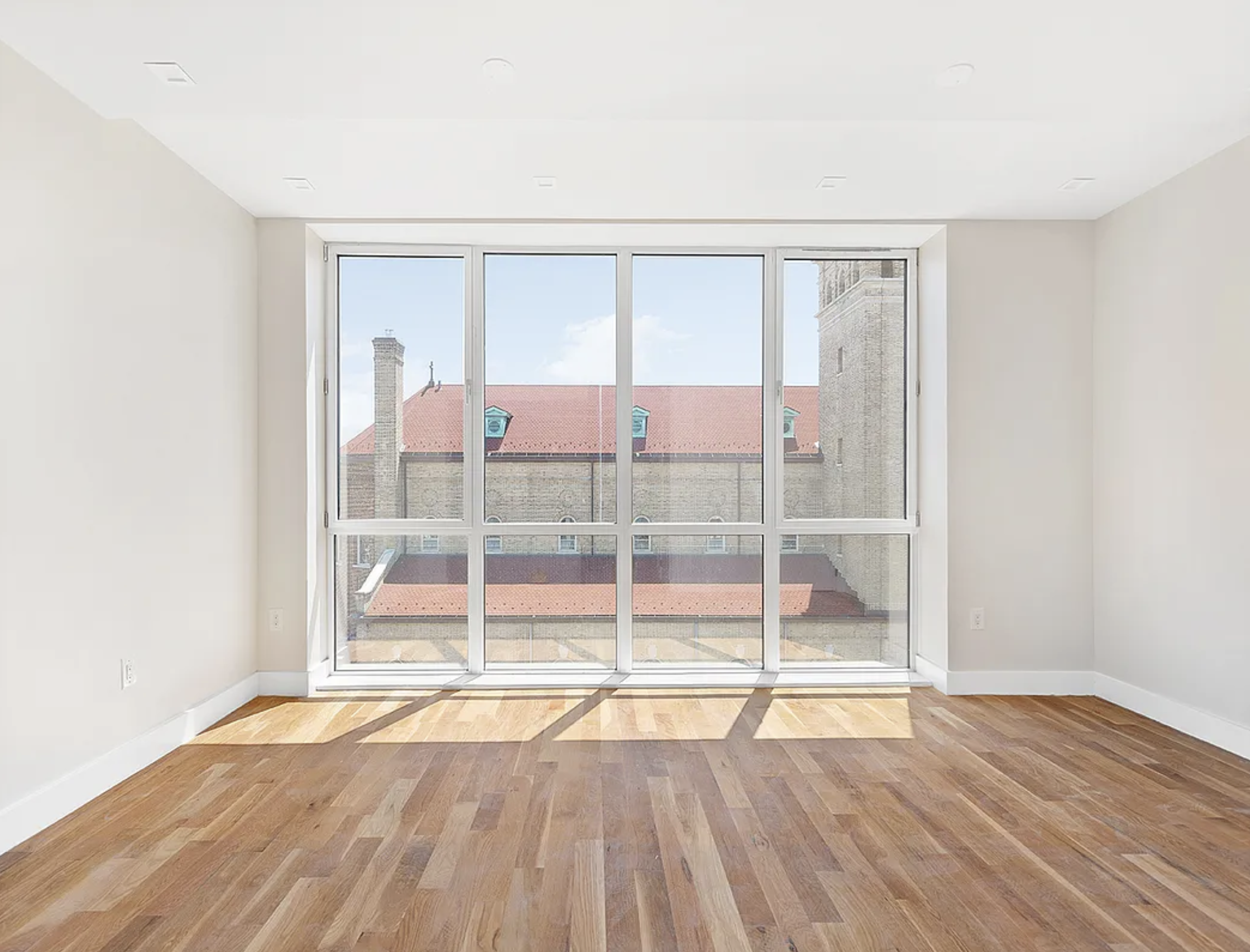 371 Lincoln Road, Unit 2 Brooklyn, NY 11225 - Photo 3 of 19 a view of an empty room with wooden floor and a window